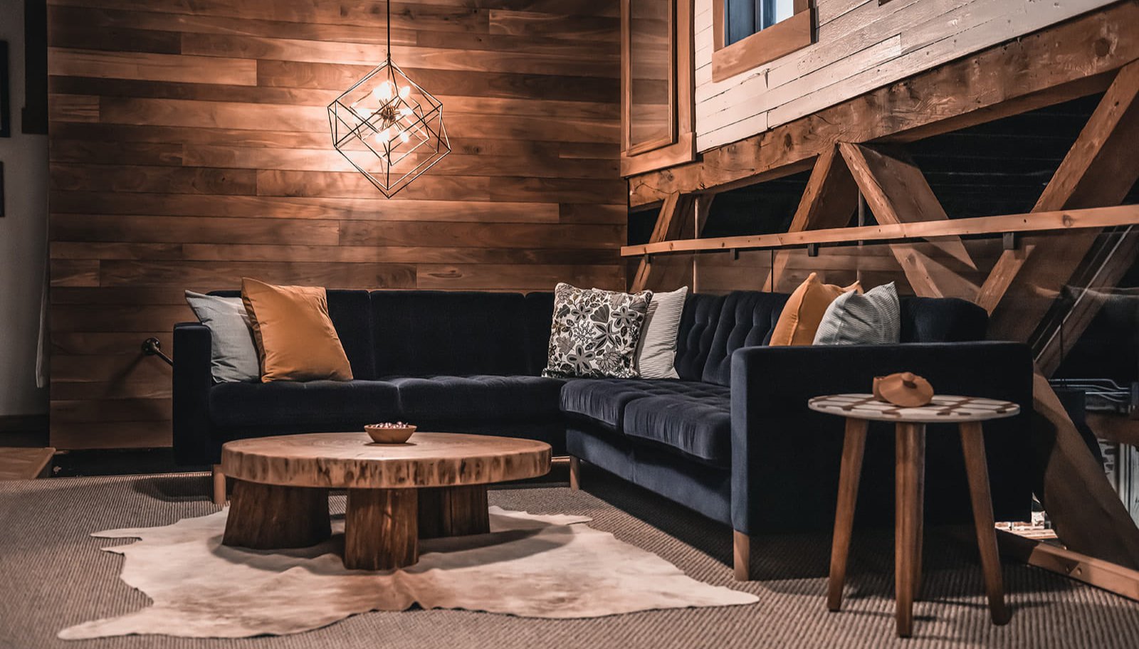 The second floor of Woodrich’s studio, featuring an organic, round coffee table, a blue sofa and soft lighting from the ceiling.